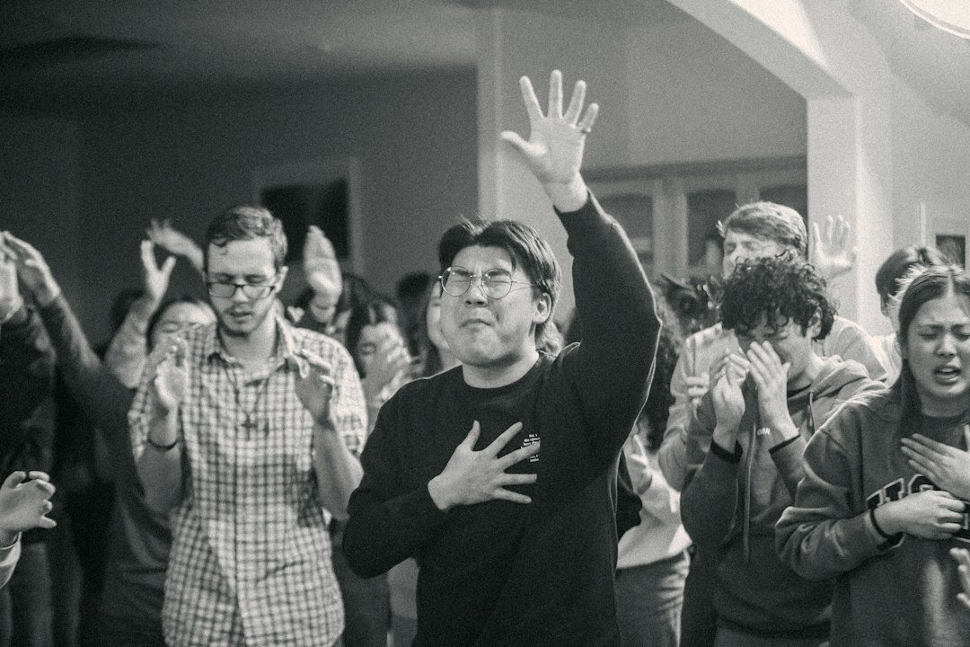 Diverse team of Singaporean software engineers celebrating with a group high five in a bright office