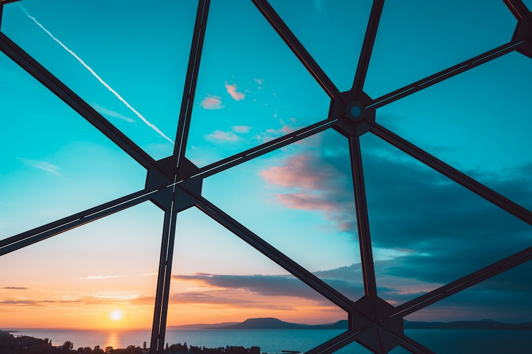 Futuristic glass dome structure glowing at sunset