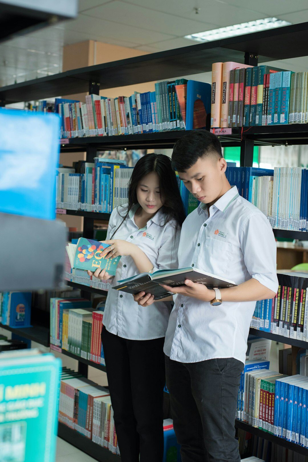 Two Singaporean colleagues reviewing a project timeline on a tablet